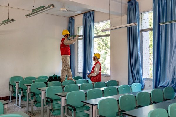 電力員工檢查教室內照明設備。國網重慶永川供電公司供圖