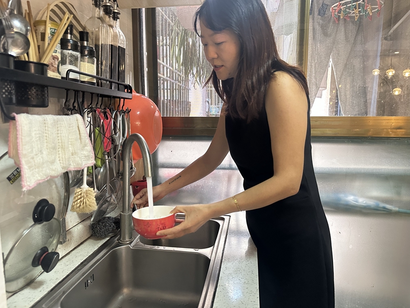 謝丹在廚房接水使用。黃亞輝攝