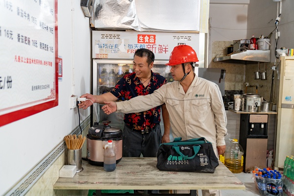 電力員工向商戶講解插座違規使用危險。國網重慶永川供電公司供圖