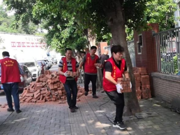 文登群（右一）帶領黨員志願者們一起修小區圍牆。九龍坡區委宣傳部供圖
