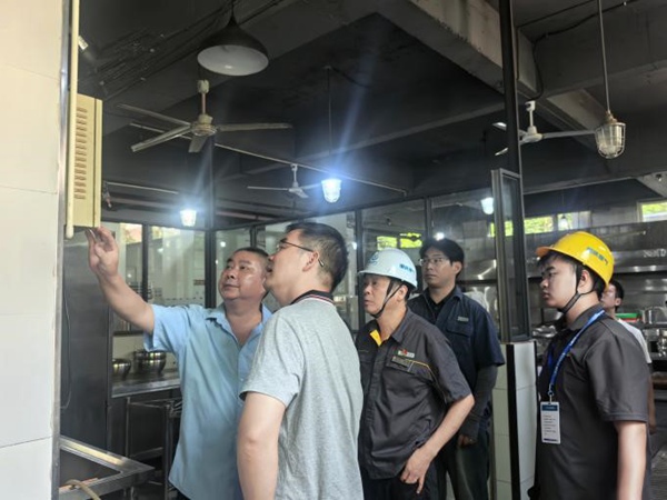 大足公司工作人員與學校食堂負責人共同排查安全隱患。重慶燃氣集團供圖