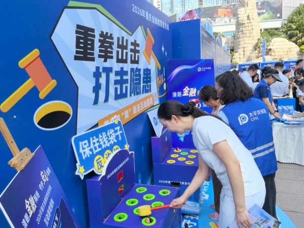中國太保產險重慶分公司工作人員引導群眾通過趣味互動游戲宣傳金融防詐知識。中國太保產險重慶分公司供圖