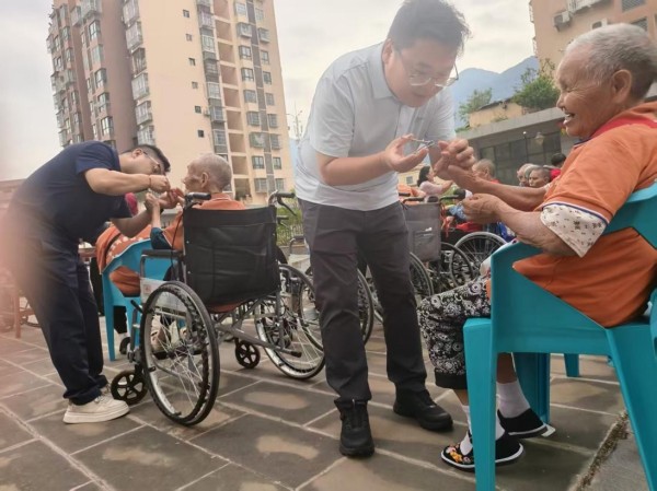 中國太保產險巫溪支公司工作人員在金融教宣之余為老年人修剪指甲。中國太保產險重慶分公司供圖