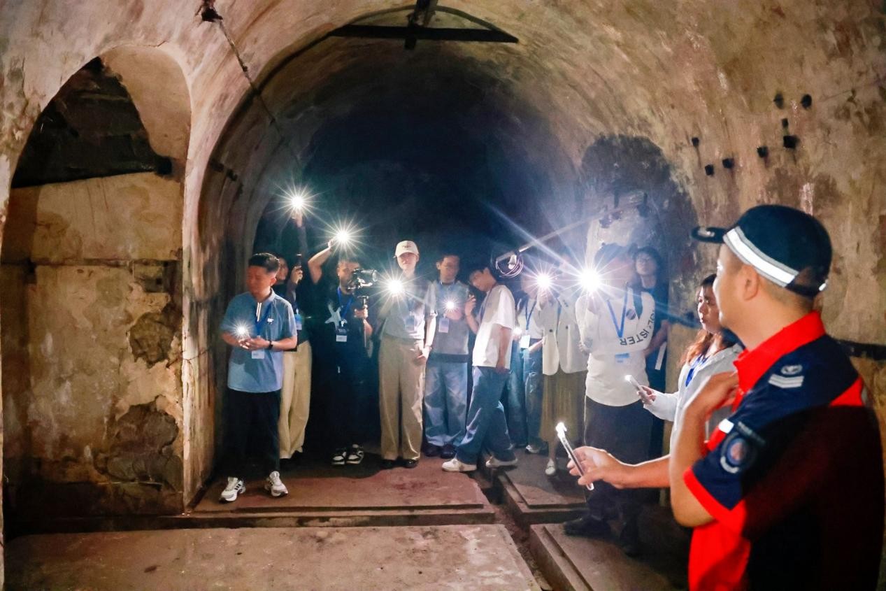 參訪團深入山洞式電台遺址，體會烽火歲月裡的通信堅守。重慶電信供圖
