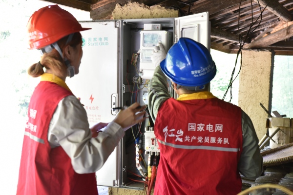 服務隊隊員到農戶家中檢查用電，保障秋收作物正常加工儲藏。鄧芝華攝