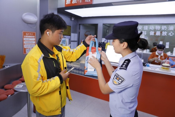 民警向外賣員提醒小票反詐內容。重慶高新區公安分局供圖