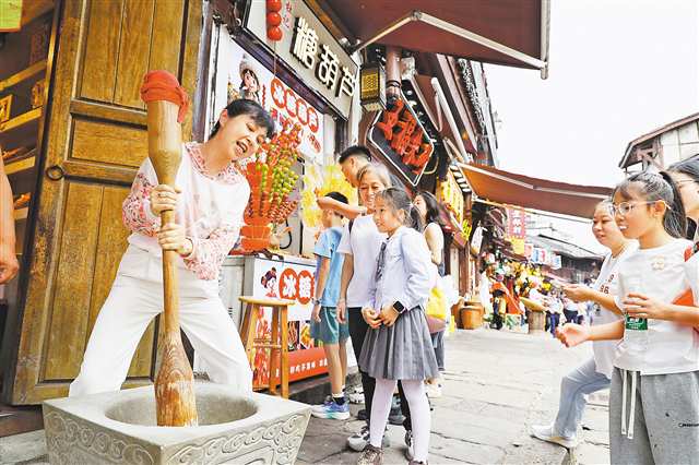 9月25日，沙坪壩區磁器口古鎮景區，游客在體驗打糍粑。特約攝影 孫凱芳/視覺重慶
