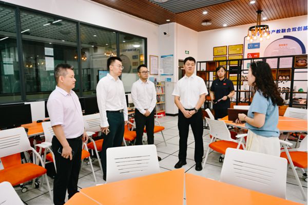 张翔（左二）带新疆梧桐树农副产品专业合作社重庆分社总经理徐勇（左四）在重庆市龙门浩职业中学校调研。