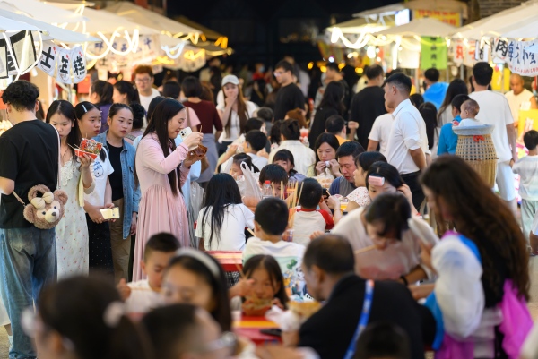 夜晚在美食街品嘗美食的游客。景區供圖