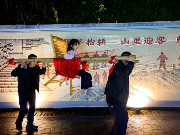 游客體驗抬滑竿。代娟攝