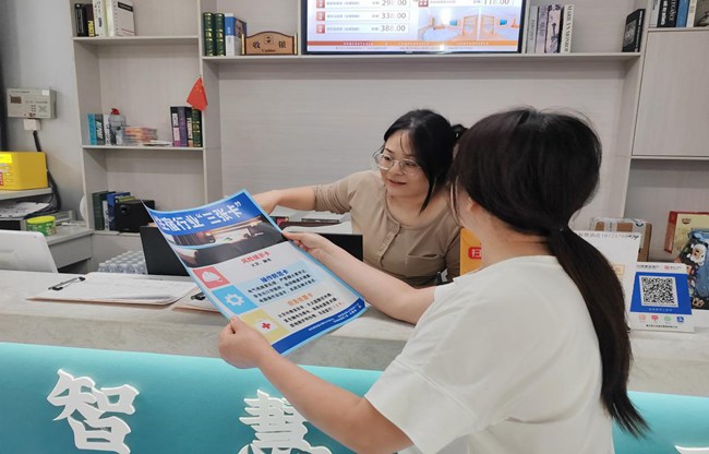 社區工作人員向轄區商戶宣傳張貼“三張卡”。林蘭攝