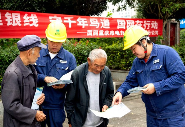国网重庆超高压公司员工在南川区水江镇护鸟宣传点向村民发放护鸟宣传资料。幸运星摄