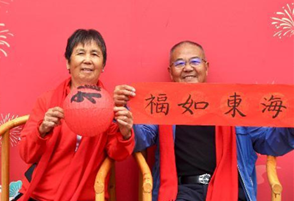 志愿者为老人们拍摄纪念照。校方供图
