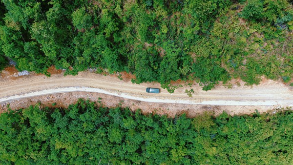 郵車穿行在山道間，郵路延伸進大山深處，郵政兜底服務，穩穩托舉“快遞進村”。中國郵政重慶市分公司供圖